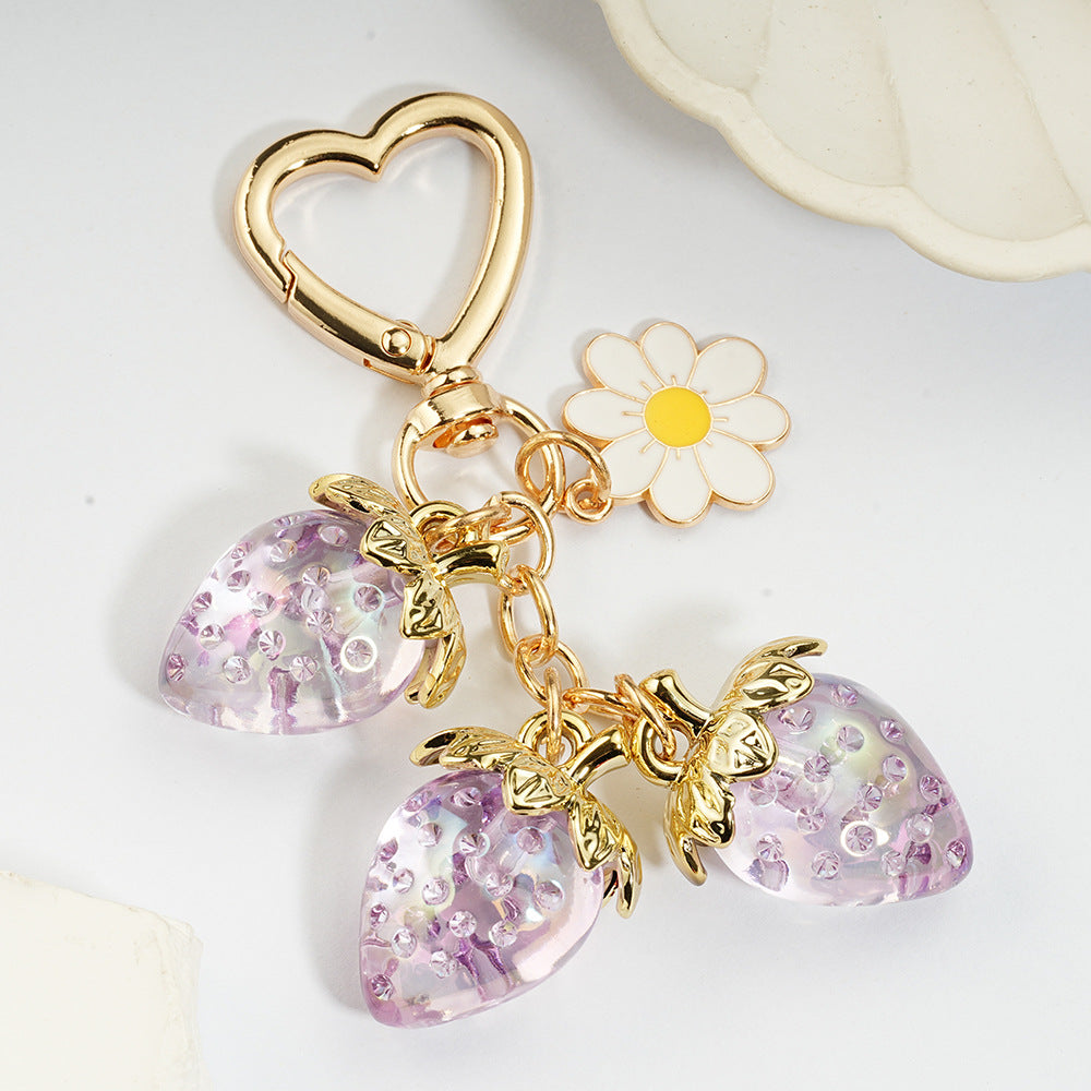 Adorable transparent strawberry keychain paired with a heart-shaped hook and daisy decorations -a sweet and stylish accessory