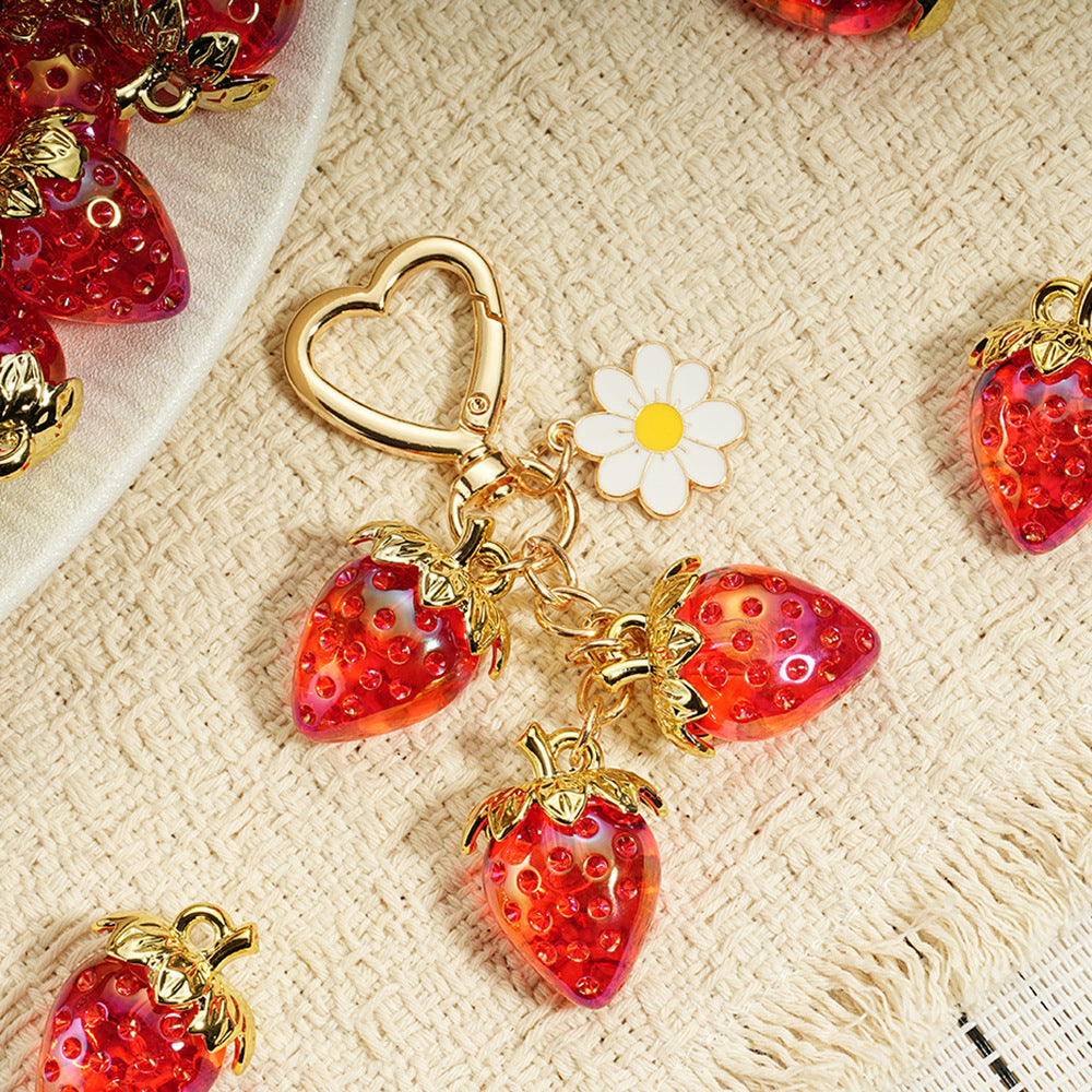 Adorable transparent strawberry keychain paired with a heart-shaped hook and daisy decorations -a sweet and stylish accessory
