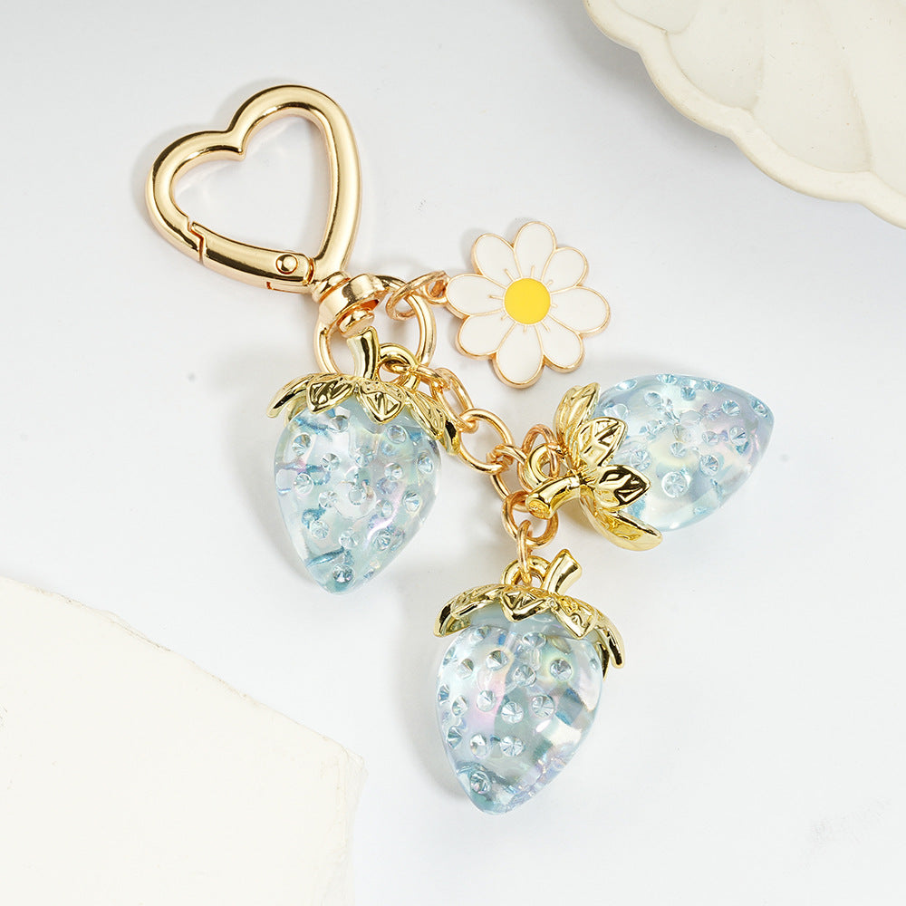 Adorable transparent strawberry keychain paired with a heart-shaped hook and daisy decorations -a sweet and stylish accessory